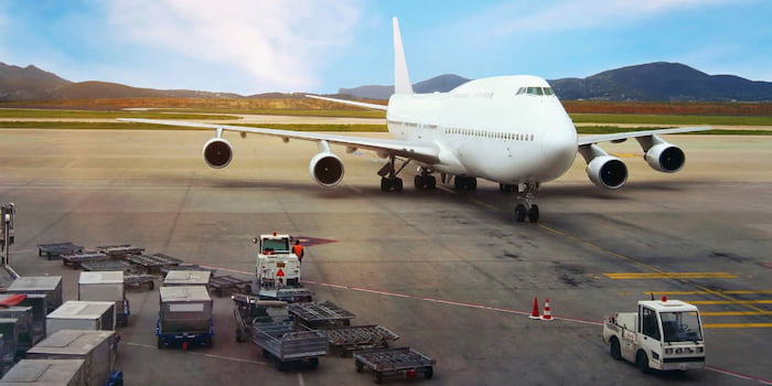 航空機とたくさんの荷物を牽引するトーイングトラクター。フレイト・フォワーディング事業イメージ